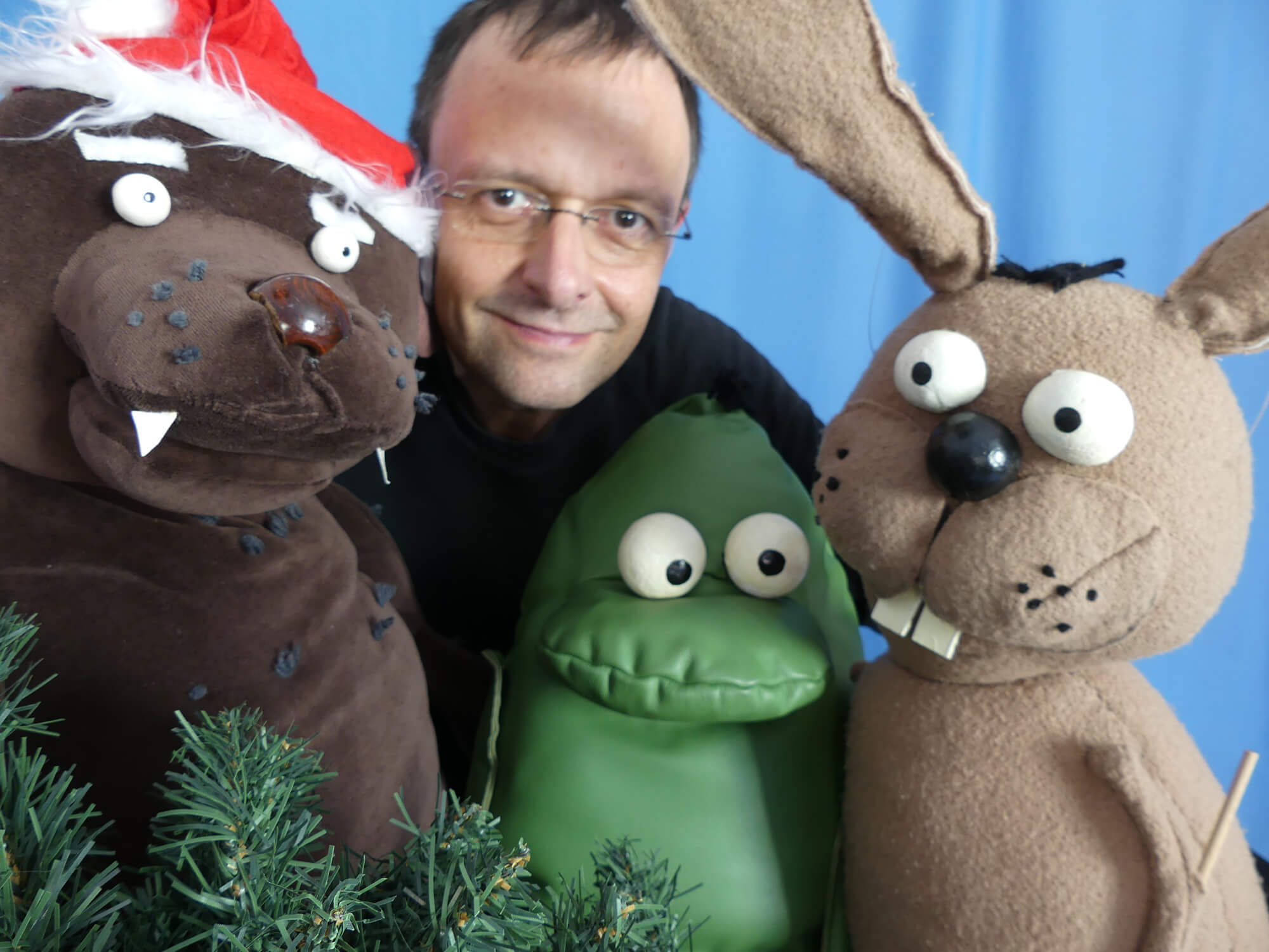 Foto: Oma Bär mit Weihnachtsmütze, Puppenspieler Wolfgang Kaup-Wellfonder, der Frosch Priesemut und der Hase Nulli